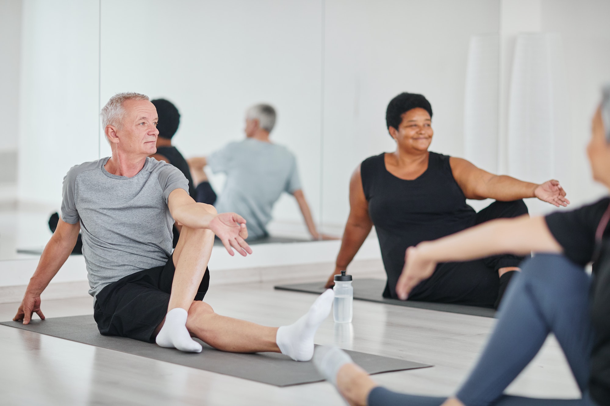 Senior man practicing yoga in class